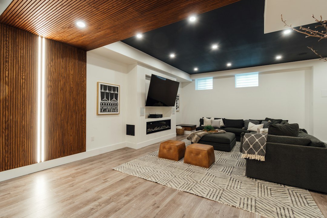 Basement family room design inspiration with wood accents, sectional seating and high windows